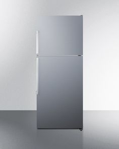 a silver refrigerator freezer sitting on top of a white floor next to a wall