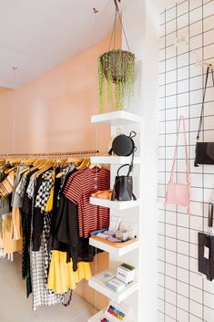 a clothing rack with handbags and purses hanging from it's shelves in a store