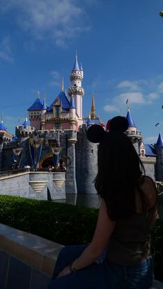 a woman sitting in front of a castle