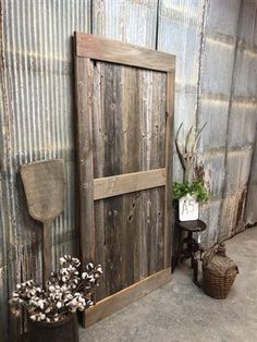 an old wooden door is next to a chair and potted plant in front of it