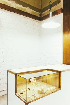 a display case in the middle of a room with white walls and wood trimmings