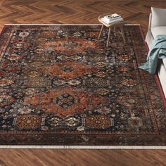 a large rug with an ornate design on the floor in front of a white couch