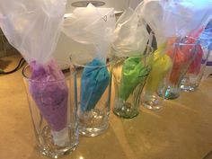 four glass vases with different colored ice cream in them sitting on a counter top