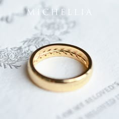 a gold wedding ring sitting on top of a piece of paper