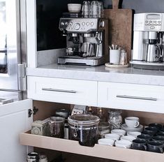 an organized kitchen with coffee maker and cups