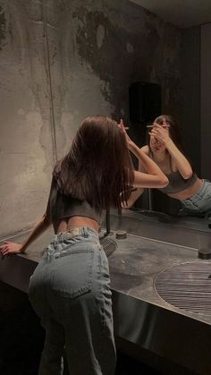 two women standing in front of a mirror brushing their teeth