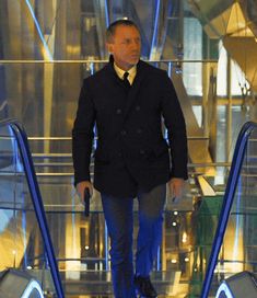 a man in a suit and tie walking down an escalator