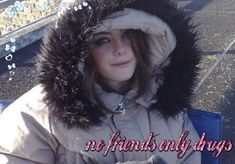 a woman sitting on the ground wearing a furry hood