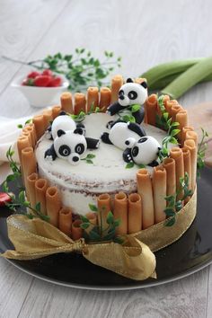 there is a cake decorated with pandas on it and bamboo sticks in the middle