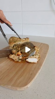 a person cutting food on top of a wooden cutting board