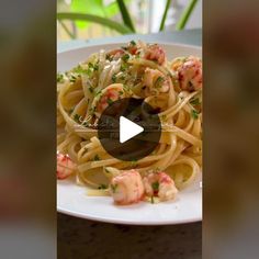 a white plate topped with pasta and shrimp