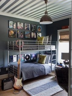 a bedroom with bunk beds and pictures on the wall above it, along with a guitar