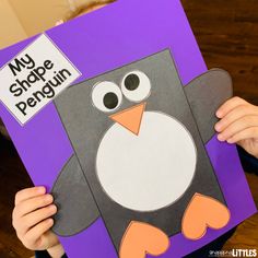 a child holding up a penguin book with the words my shoppe penguin on it