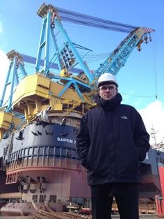 a man standing in front of a large ship