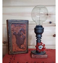 an old fashioned lamp sitting on top of a table next to a framed photo and book