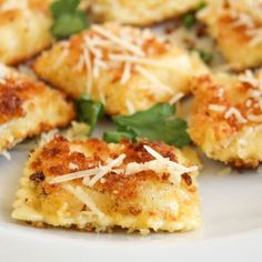 some food on a white plate with cheese and spinach sprinkled on top