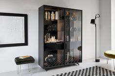 a black and white checkered rug in the middle of a room with an armoire