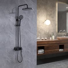 a bathroom with a sink, mirror and shower head mounted on the side of the wall