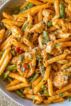 pasta with chicken and asparagus in a white bowl