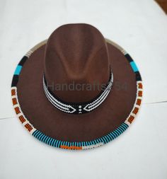 This listing is for beaded edge and brim fedora hat. The beads go around the whole edge and brim. The brim band is removable and can therefore be used on another hat. Most hat brims are one size fits all.I have made a beautiful pattern that goes all round. Instead of having a plain fedora hat, this one is more beautiful with beads. The hat is size 57. You can select a different color for the fedora hat but the beads color and pattern remains the same as shown on the photo. I ship via DHL express Handmade Brown Fedora With Short Brim, Traditional Brown Fedora Hat, Brown Handmade Fedora With Short Brim, Beaded Brown Hat Band For Festival, Beaded Brown Hat Bands For Festival, Beaded Brown Wide Brim Hat, Brown Beaded Wide Brim Hat, Festival Brown Beaded Hat Bands, Brown Wide Brim Beaded Hat