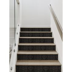 a set of stairs leading up to the second floor in a home with white walls and carpet