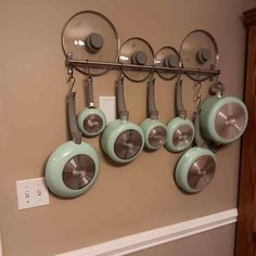 pots and pans are hanging on the wall in front of an outlet for light bulbs