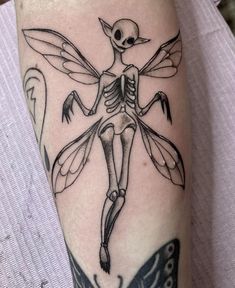 a person with a tattoo on their arm and the skeleton is flying through the air