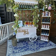 a white cart with flowers and candles on it sitting on a blue rug in front of a wooden fence