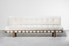 a white couch sitting on top of a wooden frame