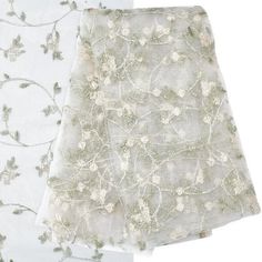 two napkins with white and green floral designs on them, one is folded to the side