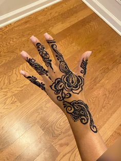 a woman's hand with henna tattoos on it