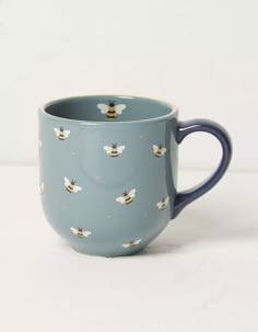 a blue coffee cup with bees on it