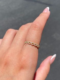 a woman's hand with a diamond ring on her left finger and white nails