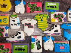 decorated cookies are arranged in the shape of baby shoes and t - shirts, along with other items