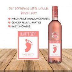 a bottle of baby foot wine sitting on top of a wooden table next to a card