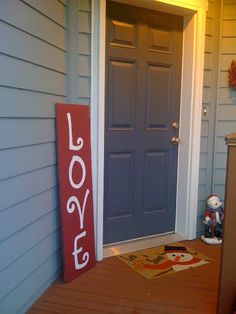 a blue door with the word love painted on it and a red sign in front