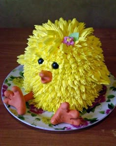 there is a cake made to look like a yellow bird on a plate with flowers