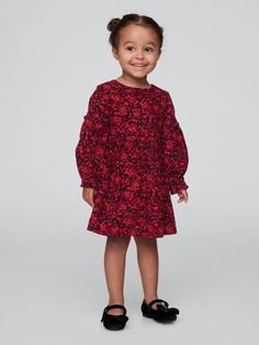 Soft cotton corduroy dress.  Round neck with back button closures.  Long sleeves with elasticized cuffs.  Ruffle details at sleeves and yoke.  Allover print.  Diaper cover up to 3 years.  Fit and flare silhouette.  Hits at the knee.  Sizes range from baby to toddler. Red Floral Print, Corduroy Dress, Diaper Cover, Baby Gap, Toddler Gifts, Dress Red, Red Floral, Fit And Flare, Baby Toddler