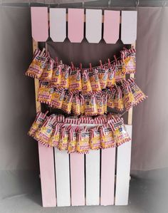 candy bars are stacked on top of each other in front of a pink and white fence