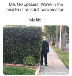 a person wearing a mask standing in front of a hedge with the caption me go upstairs we're in the middle of an adult conversation my kid