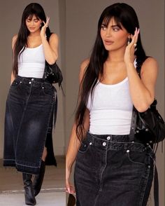 a woman in black denim skirt and white tank top talking on her cell phone while walking down the street