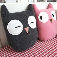 two stuffed owls sitting on top of a table