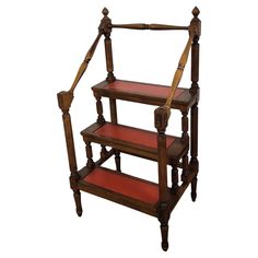 three tiered wooden shelf with red carpeting on the bottom and two shelves below