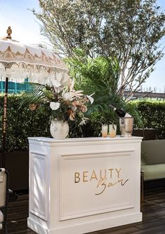 an outdoor bar is decorated with flowers and greenery