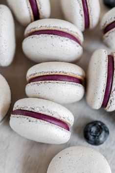 macaroons with red and white stripes are on a table next to blueberries