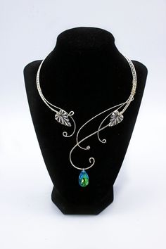 "ELVEN JEWELRY, elven necklace , fairy jewelry , silver elvish necklace with leaves , fairy necklace , torc , royal blue necklace, elf **MADE TO ORDER** (please allow up to 3-5 days for construction prior to ship) Dress it up or down!- This fantasy jewelry piece adds a unique whimsical touch to casual everyday outfits so you can stand out in a crowd.   Perfect for Renaissance fairs \\ cosplay \\ festivals \\ proms \\ wedding \\ elven and fairy fantasy costumes \\ unique gift idea    A beautiful elegant elven necklace woven from silver plated wire, featuring two silver leaves  and a large 22 mm faceted glass crystal. (You can choose the color in the drop down menu. \"Bermuda Blue\" is what is shown in the first photo). Necklace curves around the back of the neck and sits open in the front - Elvish Style Jewelry Gift, Elven Style Metal Jewelry Gift, Elven Style Metal Jewelry For Gifts, Handmade Adjustable Elven Jewelry, Adjustable Elven Style Metal Jewelry, Handmade Elven Jewelry For Wedding, Handmade Silver Elven Jewelry, Adjustable Silver Elven Jewelry, Silver Fantasy Choker Necklace