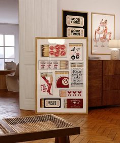 a wooden table sitting next to a wall with pictures on it and other items in the background