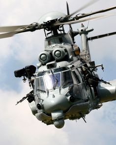 a black and white photo of a helicopter flying in the sky