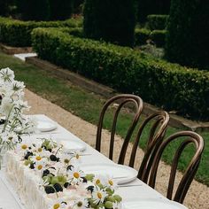 a long table with flowers and plates on it