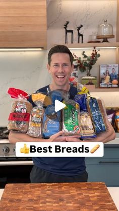 the man is holding up some breads in his hands and smiling at the camera